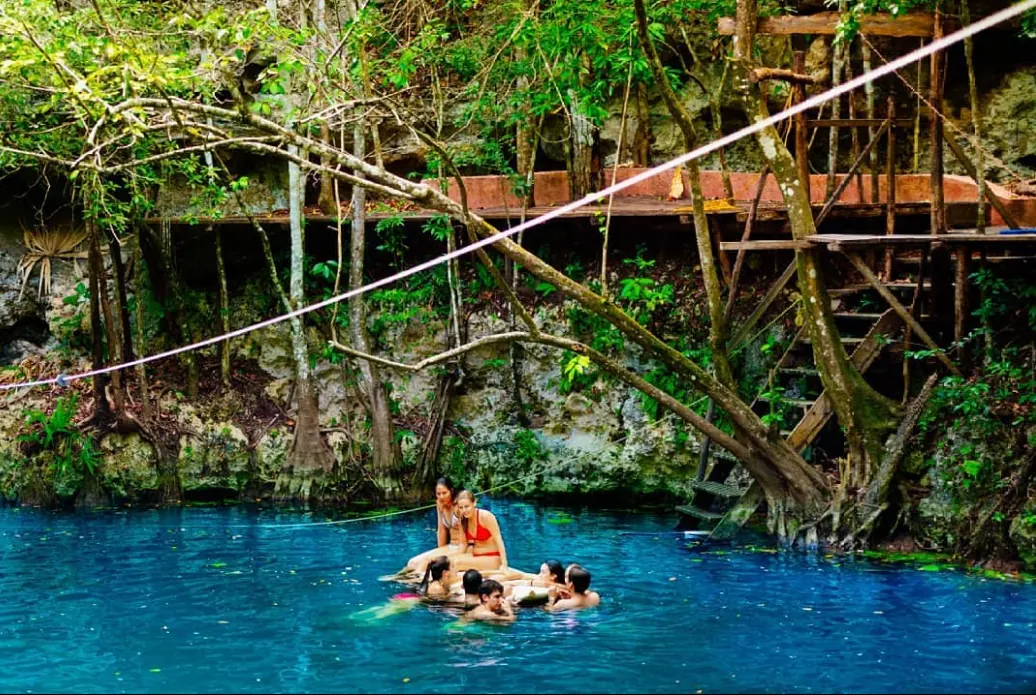 Visitantes nadando en el cenote Blanca Flor